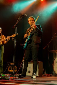 a group of people playing guitars on stage